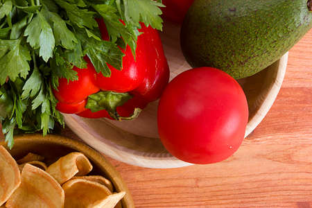Ingredients for guacamole in a wooden bowl on the table