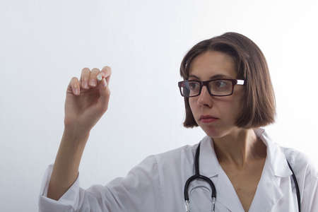 Female medical student with chalk in hand on white backgroundの写真素材