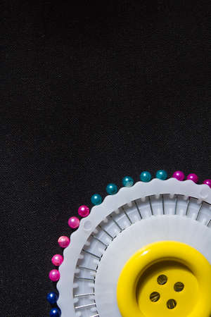 Set of colorful safety pins on black fabric backgroundの写真素材
