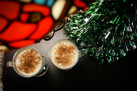 Christmas eggnog milkshake on table with christmas tree and table lampの写真素材
