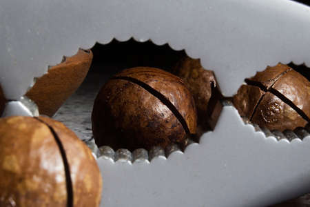 Macadamia nuts and nutcracker on wooden table