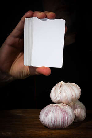 Garlic heads and cards on black backgroundの写真素材