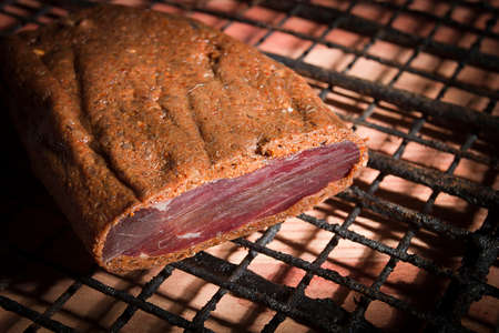 Smoked meat on a wire rack on a wooden table background