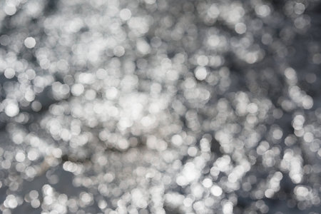Lights Festive background. Abstract twinkled background with bokeh defocused silver lightsの写真素材