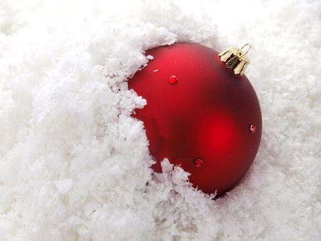 Red Christmas ball with a snow background の写真素材