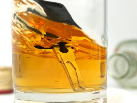 A car key in a glass of whiskyの写真素材