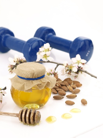 Honey in a jar, almonds, flowers and weightsの写真素材