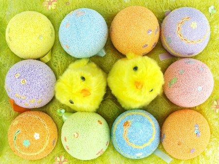 Colorful Easter eggs and cute chickens in a decorative grass eggs case 