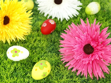 Spring flowers and colorful Easter eggs over grassの写真素材