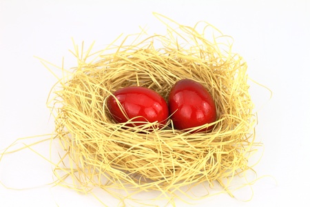 Red eastern eggs in the nest over white background の写真素材