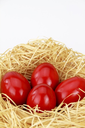 Red easter eggs in the nest over white backgroundの写真素材