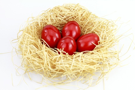 Red easter eggs in the nest over white background の写真素材