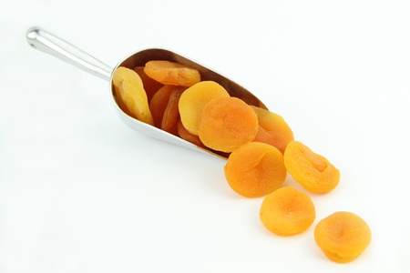 Dried apricots in scoop isolated on white backgroundの写真素材