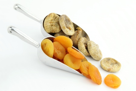 Dried apricots and figs in scoop isolated on white backgroundの写真素材