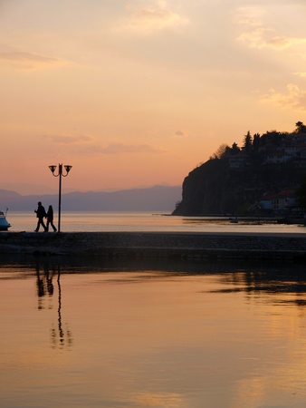 Romantic couple walk on the jetty at sunset   の写真素材