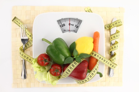Vegetables with measuring tape on a plate as weight scale の写真素材