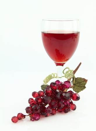 Rose wine in glass with shiny stone grape branchの写真素材