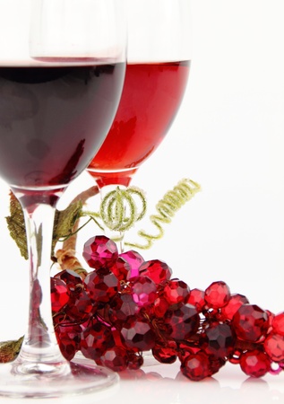 Red wine in glasses with shiny stone grape branchの写真素材