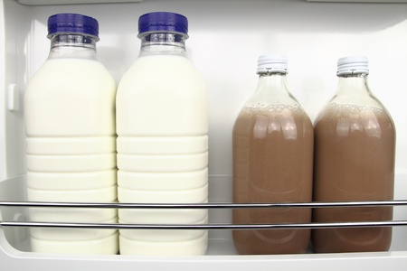 Bottles of white and chocolate milk in the fridgeの写真素材