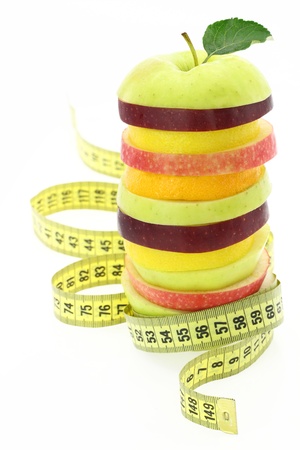 Diet concept. Fruits with measuring tapeの写真素材