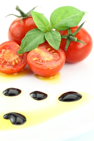 Tomato and basil garnished with olive oil and balsamic vinegarの写真素材
