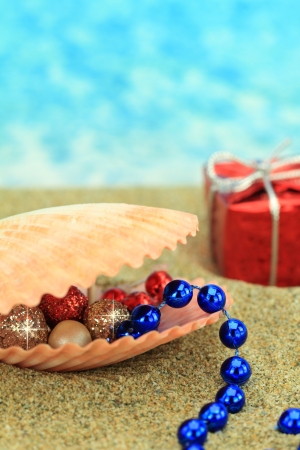 Christmas ornaments in a sea shell on the beach の写真素材