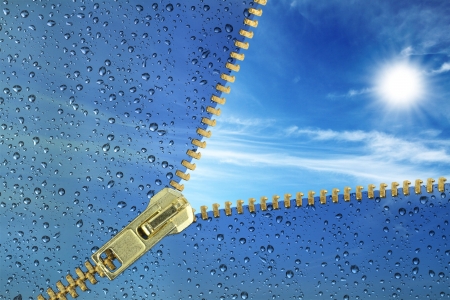 Unzipped glass with water drops revealing blue sky の写真素材