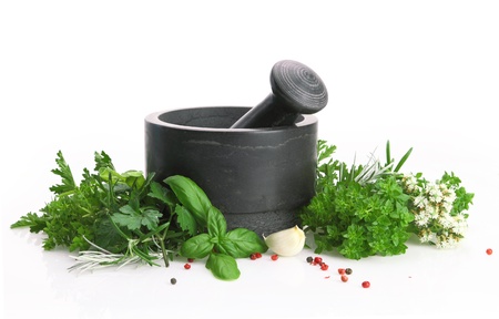 Black stone mortar and pestle with fresh herbsの写真素材
