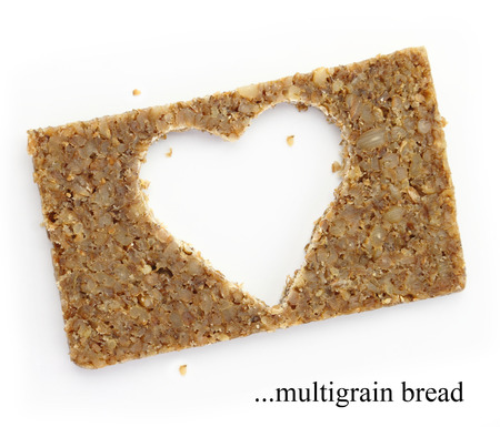 Multigrain slice of bread with copy space in shape of heart, isolated on white