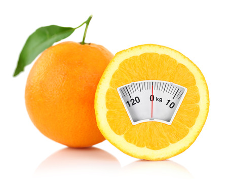 Weight scale on an orange, diet concept の写真素材