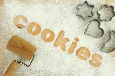 Stencil word "cookies" made with flour on wooden tableの写真素材