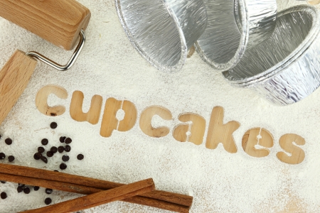 Stencil word "cupcakes" made with flour on wooden tableの写真素材