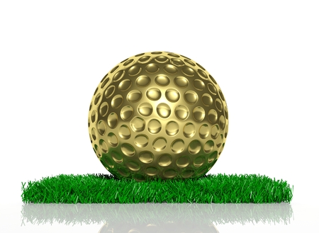 Gold golf ball on patch of green grass の写真素材