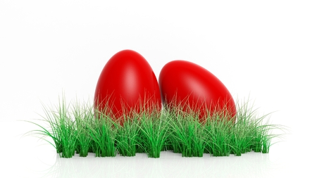 Two red painted Easter eggs with green grass isolated の写真素材