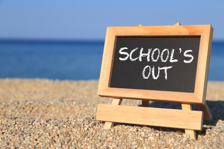 Blackboard with School's out text on the beach の写真素材