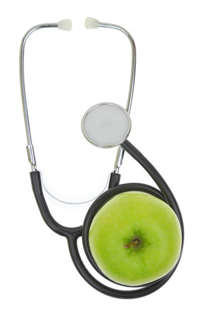 Stethoscope with green apple isolated on white の写真素材