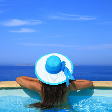 Woman overlooking the sea from swimming pool の写真素材