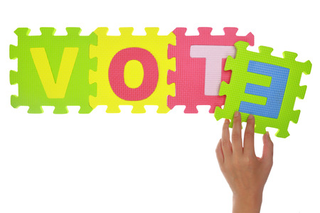 Hands forming word Vote with jigsaw puzzle pieces isolated