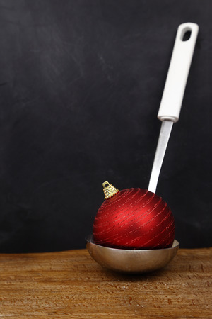 Christmas ball in a serving spoon and copy space on black backgroundの写真素材