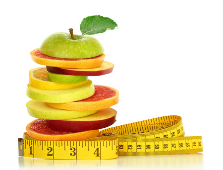 Fresh fruit slices and measuring tape isolated on whiteの写真素材