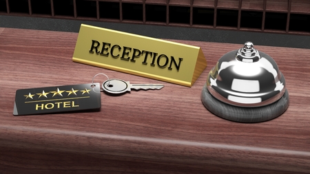 Hotel reception bell and and key on reception wooden deskの写真素材
