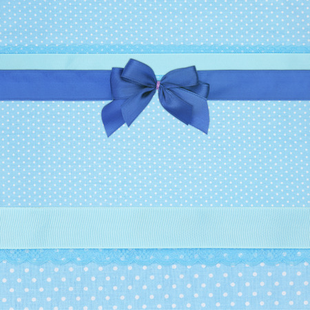 Blue retro polka dot textile background with ribbons and bowの写真素材