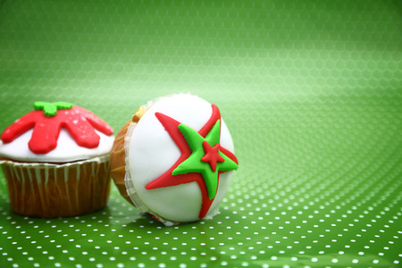 Festive Christmas cupcakes on green polka dot backgroundの写真素材