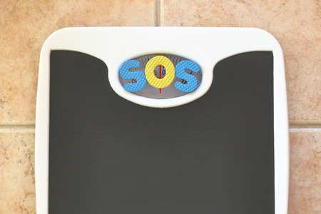 Bathroom scale with SOS text. Diet conceptの写真素材