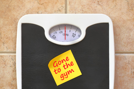 Bathroom scale with Go to Gym memo sticker. Diet and fitness conceptの写真素材