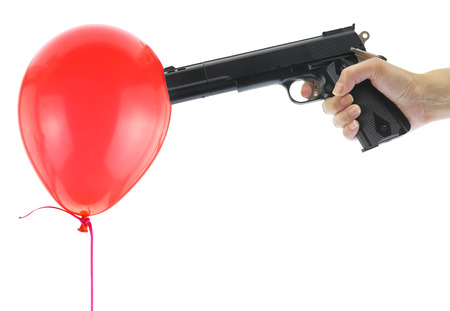 Hand holding at gunpoint a red balloon isolated on whiteの写真素材