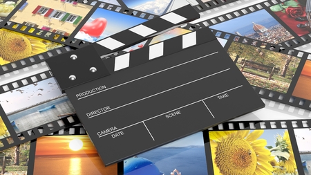 Clapperboard on filmstrips with pictures as backgroundの写真素材