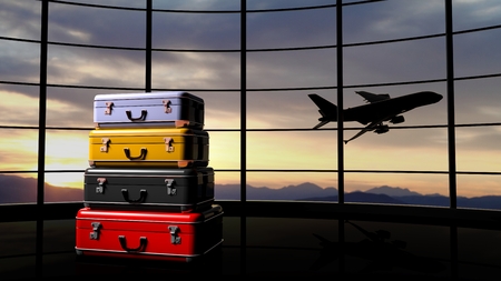 Stack of suitcases beside airpot window with sunset and airplane in flightの写真素材