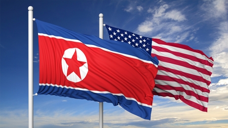 Waving flags of North Korea and USA on flagpole, on blue sky background.の写真素材