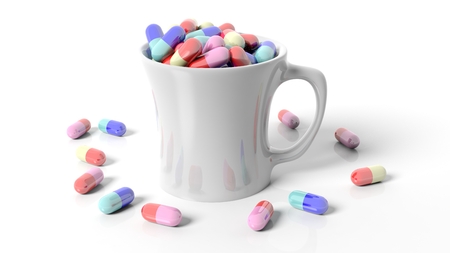 Coffee mug full of pills,isolated on white background.の写真素材